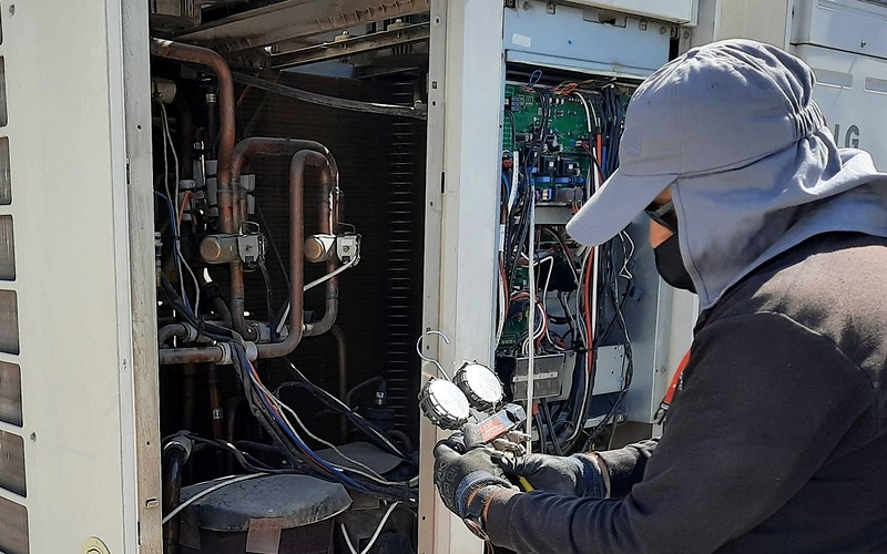 Técnico midiendo presiones en una unidad de clima